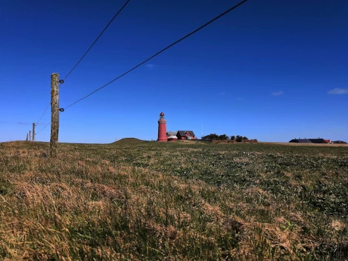 Red lighthouse on a fresh meadow. Dreamlike!